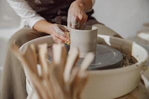 dichtbij omhoog van handen van professioneel pottenbakker gieten pot vorm Aan pottenbakkerij wiel. keramiek kunst concept foto