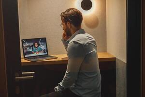 mannetje freelancer hebben een videoconferentie met collega terwijl zittend in knus coworking foto