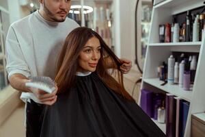 vrouw op zoek Bij haarzelf in spiegel, verheugd met een kapsel Bij schoonheid salon foto