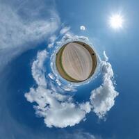 gemakkelijk klein planeet zonder gebouwen in blauw lucht met mooi wolken. transformatie van bolvormig panorama 360 graden. bolvormig abstract antenne visie. kromming van ruimte. foto