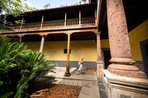 een meisje in een gestreept jurk wandelingen door de oud stad- centrum van la laguna in tenerife, kanarie eilanden, Spanje foto