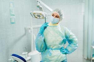 een gemaskeerd tandarts houdt een injectie injectiespuit voor een geduldig in de kantoor foto