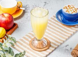 bevroren Kumquat citroen thee in een glas Aan mat met grijs achtergrond ontbijt drinken foto