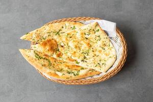 tandoori groen knoflook naan of brood geserveerd in mand geïsoleerd Aan tafel top visie van Aziatisch en Indisch voedsel foto