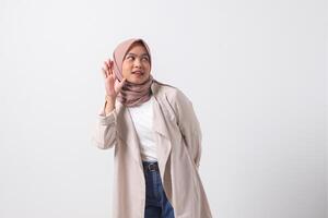 portret van opgewonden Aziatisch hijab vrouw in gewoontjes pak schreeuwen Aankondiging en fluisteren geroddel. zakenvrouw concept. geïsoleerd beeld Aan wit achtergrond foto