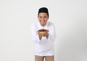 portret van opgewonden Aziatisch moslim Mens aan het eten datum fruit gedurende sahur of breken de snel. cultuur en traditie Aan Ramadan maand. geïsoleerd beeld Aan wit achtergrond foto