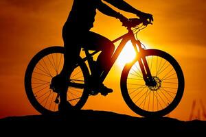 silhouet van een fiets met een Mens Aan lucht achtergrond Aan zonsondergang. gedetailleerd foto. detailopname foto