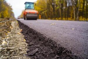 weg reparatie, compactor legt asfalt. zwaar speciaal machines. asfalt bestratingsafwerkmachine in operatie. kant visie. detailopname. foto