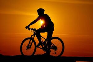 silhouet van een fietser Aan lucht achtergrond Aan zonsondergang. hoog heuvel top en breed rivier- Aan oranje zonsondergang. foto
