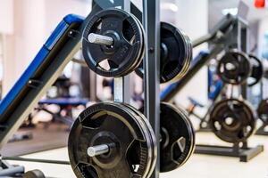 pannekoeken Aan een halter in een Sportschool. sport en gezond leven concept. reeks van pannekoeken Aan Sportschool achtergrond. sport uitrusting detailopname. foto