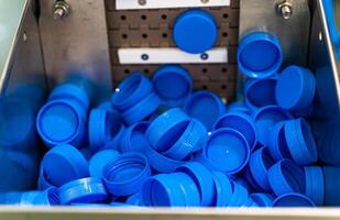 productie en bottelen van yoghurt of melk. plastic blauw kopjes. uitrusting Bij de zuivel fabriek. foto