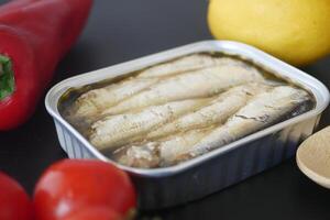 open blikje sardines op witte tegels achtergrond. foto