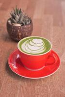 matcha latte in een rood kleur kop Aan tafel foto