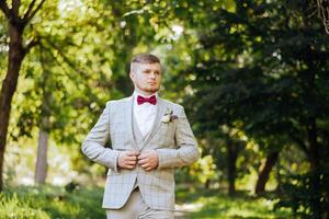 portret van een knap jong bruidegom Aan een herfst dag buitenshuis in een elegant pak. buitenshuis foto. knap Mens in een bedrijf pak. foto