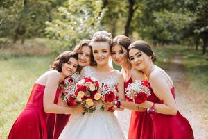 bruiloft fotografie. een brunette bruid in een wit jurk met een boeket en haar brunette vriendinnetjes foto