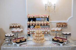 amandel koekjes, zoet cakes voor een bruiloft banket. een heerlijk ontvangst, een luxueus ceremonie. tafel met snoepgoed en desserts. heerlijk kleurrijk Frans desserts Aan een bord of tafel. snoep bar. foto