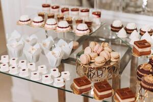 amandel koekjes, zoet cakes voor een bruiloft banket. een heerlijk ontvangst, een luxueus ceremonie. tafel met snoepgoed en desserts. heerlijk kleurrijk Frans desserts Aan een bord of tafel. snoep bar. foto