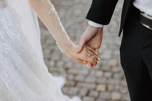 samen wij maken de wereld beter. detailopname visie van getrouwd paar Holding handen. bruid en bruidegom hand- in hand- foto