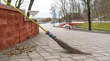 retro bezem gemaakt van droog takken tegen de backdrop van een stad park. foto