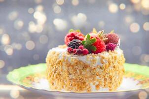 taart gedekt met bessen tegen een gouden bokeh achtergrond. foto