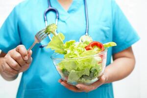 Aziatisch voedingsdeskundige Holding gezond voedsel voor geduldig in ziekenhuis, voeding en vitamine. foto