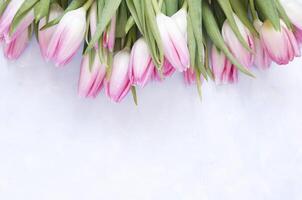 bloemen achtergrond met tulpen bloemen Aan blauw abstract achtergrond. vlak leggen, top visie. lief groet kaart met tulpen voor moeders dag, bruiloft of gelukkig evenement foto