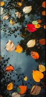ai gegenereerd een abstract samenstelling van kleurrijk herfst bladeren drijvend Aan een reflecterende water oppervlakte van een vijver foto
