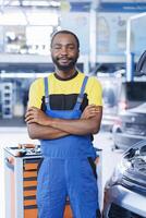 portret van trots bipoc militair in auto reparatie winkel belast met veranderen auto's olie. licentie specialist in garage klaar naar begin aan het doen controles Aan voertuigen in garage werkruimte foto