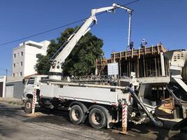 pompen beton door vrachtauto in bouw foto