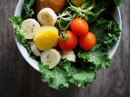 kleurrijk groente salade Aan hout tafel boerenkool en zonnebloem spruit foto