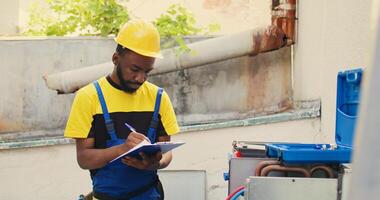 goed geïnformeerd ingenieur aan het doen lekken cheques en andere vereist reparaties naar voorkomen majoor hvac systeem mislukkingen. doeltreffend technicus verifiëren lucht conditioner, schrijven bevindingen Aan klembord foto