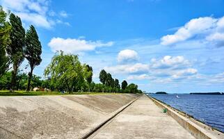 steen dijk met bomen Aan een warm zomer voorjaar dag foto