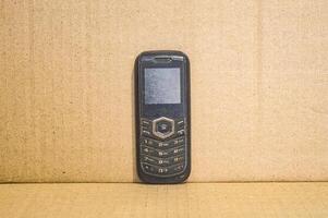 oud mobiele telefoon met een duidelijk bruin achtergrond foto