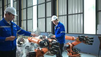 ingenieur en technicus werken met robot arm in fabriek. industrie en bouwkunde concept. foto