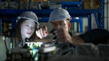 een jong vrouw ingenieur en een mannetje leidinggevende werk samen in robot arm Reserve onderdelen magazijn, robot arm industrie en bouwkunde concept. foto