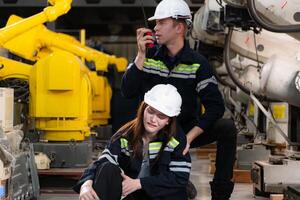 een vrouw arbeider geleden een been ongeluk terwijl werken in robot armen fabriek en mannetje technicus vragen voor eerste steun bijstand foto