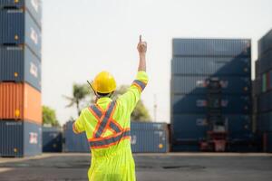 arbeiders in de importeren en exporteren industrie gebruik walkie talkies naar communiceren met chauffeurs van bereiken stapelaar containers in een leeg houder magazijn. foto