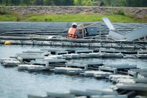 technicus momenteel evalueren en repareren de transmissie terminals voor elektriciteit gegenereerd door zonne- energie in een drijvend zonne- macht systeem. foto