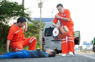 de paramedicus is assisteren een gewond Mens in een noodgeval situatie Aan de weg. foto