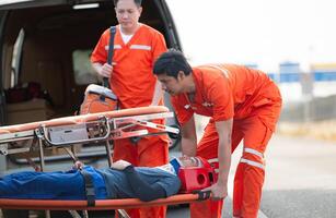 de paramedicus is assisteren een gewond Mens in een noodgeval situatie Aan de weg. foto