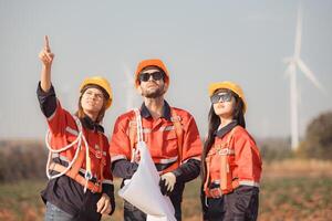 team van ingenieurs en architecten werken Aan wind turbines in een wind boerderij foto