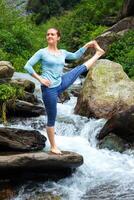 vrouw aan het doen Ashtanga Vinyasa yoga asana buitenshuis Bij waterval foto