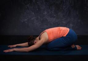 mooi sportief fit yogi meisje praktijken yoga asana balasana foto