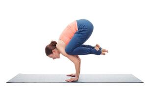 fit yogini vrouw praktijken yoga asana bakasana foto