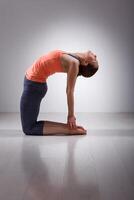 mooi sportief fit yogini vrouw praktijken yoga asana ustrasana foto