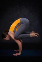 fit yogini vrouw praktijken yoga asana bakasana foto