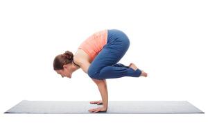 mooi sportief fit yogini vrouw praktijken yoga asana kakasana foto