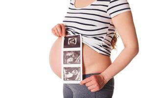 zwanger vrouw staand en Holding haar echografie baby scannen foto