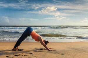 vrouw aan het doen yoga surya namaskar oudoors Bij tropisch strand foto