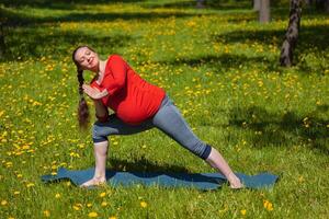 zwanger vrouw aan het doen asana utthita parsvakonasana buitenshuis foto